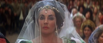 Movie still from “The Taming of The Shrew” (1967), directed by Franco Zeffirelli – A person wearing a dress and a veil; Close Up shot, Over the shoulder angle