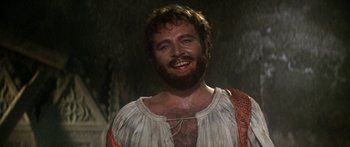 Movie still from “The Taming of The Shrew” (1967), directed by Franco Zeffirelli – A man with a beard is smiling for the camera; Close Up shot, Low angle