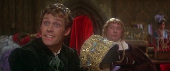 Movie still from “The Taming of The Shrew” (1967), directed by Franco Zeffirelli – A man sitting next to another man wearing a hat; Close Up shot, Over the shoulder angle