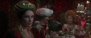 Movie still from “The Taming of The Shrew” (1967), directed by Franco Zeffirelli – A group of people sitting at a table holding wine glasses; Close Up shot, Over the shoulder angle