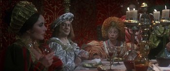 Movie still from “The Taming of The Shrew” (1967), directed by Franco Zeffirelli – Two people sitting at a dinner table with food on the table; Medium shot, Over the shoulder angle