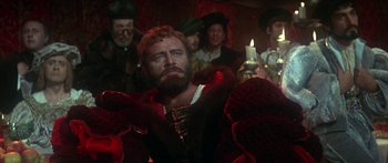 Movie still from “The Taming of The Shrew” (1967), directed by Franco Zeffirelli – A group of people in a dark room with a candle; Medium shot, Over the shoulder angle