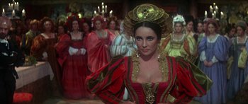 Movie still from “The Taming of The Shrew” (1967), directed by Franco Zeffirelli – A group of people in costumes in a room; Medium shot, Over the shoulder angle