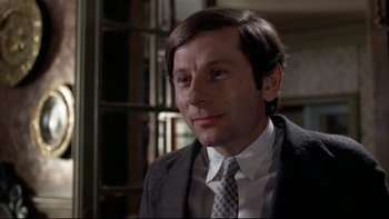 Movie still from “The Tenant” (1976), directed by Roman Polanski – A person wearing a suit and tie; Close Up shot, Low angle