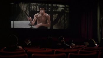 Movie still from “The Tenant” (1976), directed by Roman Polanski – People sitting in a movie theater watching a movie; Wide shot, Low angle