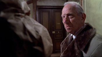 Movie still from “The Tenant” (1976), directed by Roman Polanski – An older man wearing a suit and tie looking at another man; Close Up shot, Low angle