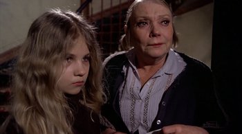 Movie still from “The Tenant” (1976), directed by Roman Polanski – A woman and a young girl are looking at the camera; Close Up shot, High angle