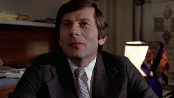 Movie still from “The Tenant” (1976), directed by Roman Polanski – A person wearing a suit and tie; Close Up shot, Low angle