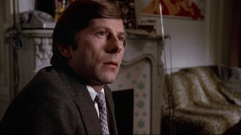 Movie still from “The Tenant” (1976), directed by Roman Polanski – A person wearing a suit and tie; Close Up shot, Low angle