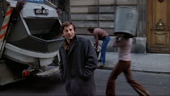 Movie still from “The Tenant” (1976), directed by Roman Polanski – A man standing on the side of the street; Medium shot, Over the shoulder angle