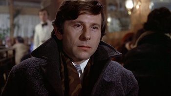 Movie still from “The Tenant” (1976), directed by Roman Polanski – A person wearing a coat and tie; Close Up shot, Low angle