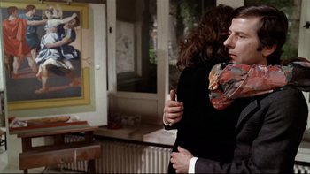 Movie still from “The Tenant” (1976), directed by Roman Polanski – A man and a woman hugging in a living room; Medium shot, Over the shoulder angle
