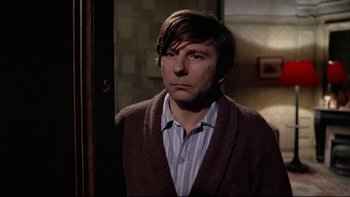 Movie still from “The Tenant” (1976), directed by Roman Polanski – A man standing in front of a mirror in front of a door; Close Up shot, Over the shoulder angle