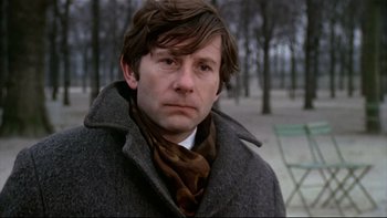 Movie still from “The Tenant” (1976), directed by Roman Polanski – A person wearing a coat and a scarf; Close Up shot, Over the shoulder angle