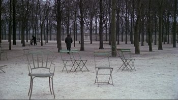 Movie still from “The Tenant” (1976), directed by Roman Polanski – A person walking in a park with a lot of empty chairs; Extreme Wide shot, High angle