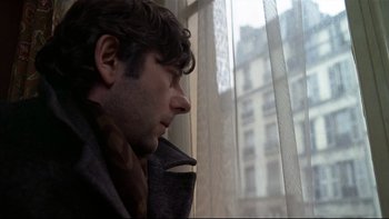 Movie still from “The Tenant” (1976), directed by Roman Polanski – A man sitting in front of a window looking outside; Close Up shot, Low angle