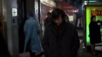 Movie still from “The Tenant” (1976), directed by Roman Polanski – A man is walking down the street at night; Medium shot, High angle