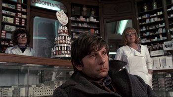 Movie still from “The Tenant” (1976), directed by Roman Polanski – A man and a woman are standing in a store; Medium shot, Low angle