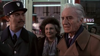 Movie still from “The Tenant” (1976), directed by Roman Polanski – A group of people standing next to each other on the street; Close Up shot, Over the shoulder angle