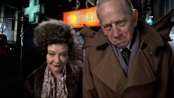 Movie still from “The Tenant” (1976), directed by Roman Polanski – An older man and a younger woman standing next to each other; Medium shot, Low angle