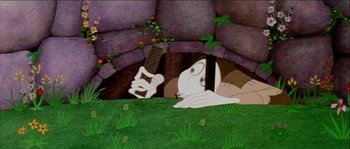 Movie still from “The Thief and the Cobbler” (1993), directed by Richard Williams – A man laying in the grass holding a knife; Wide shot, High angle