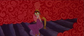 Movie still from “The Thief and the Cobbler” (1993), directed by Richard Williams – A woman sitting on the ground in front of a red wall; Wide shot, High angle