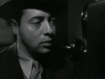 Movie still from “The Thin Man” (1934), directed by W.S. Van Dyke – A black and white photo of a man in a suit and tie; Close Up shot, Low angle