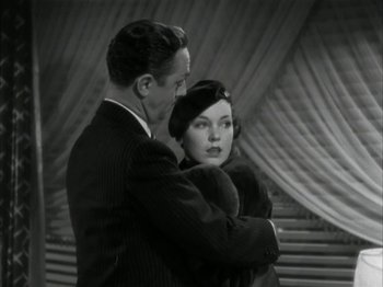 Movie still from “The Thin Man” (1934), directed by W.S. Van Dyke – A man and a woman standing next to each other; Medium shot, High angle