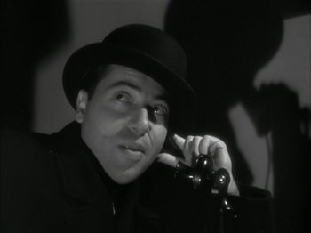 Movie still from “The Thin Man” (1934), directed by W.S. Van Dyke – A black and white photo of a man talking on a phone; Close Up shot, Low angle