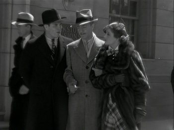Movie still from “The Thin Man” (1934), directed by W.S. Van Dyke – A group of people standing next to each other on the street; Medium shot, High angle