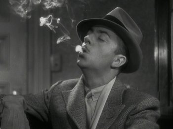 Movie still from “The Thin Man” (1934), directed by W.S. Van Dyke – A black and white photo of a man smoking a cigarette; Close Up shot, Low angle