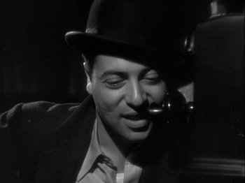 Movie still from “The Thin Man” (1934), directed by W.S. Van Dyke – A black and white photo of a man in a hat; Close Up shot, Low angle