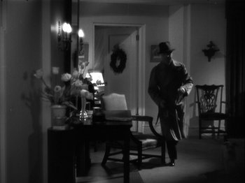 Movie still from “The Thin Man” (1934), directed by W.S. Van Dyke – A black and white photo of a man in a hat; Wide shot, High angle
