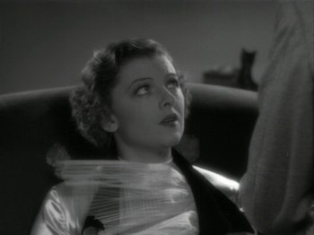 Movie still from “The Thin Man” (1934), directed by W.S. Van Dyke – A black and white photo of a woman sitting on a couch; Close Up shot, High angle