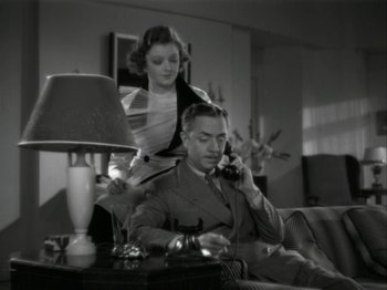 Movie still from “The Thin Man” (1934), directed by W.S. Van Dyke – A man and a woman sitting at a table talking on the phone; Medium shot, High angle
