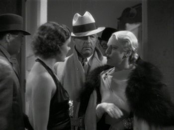 Movie still from “The Thin Man” (1934), directed by W.S. Van Dyke – A man and two women are talking to each other; Medium shot, Over the shoulder angle