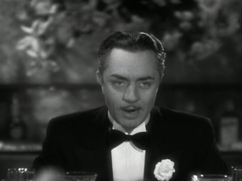 Movie still from “The Thin Man” (1934), directed by W.S. Van Dyke – A man in a tuxedo is holding a wine glass; Close Up shot, High angle
