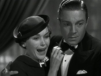 Movie still from “The Thin Man” (1934), directed by W.S. Van Dyke – An old photo of a man and a woman posing for a picture; Close Up shot, Low angle