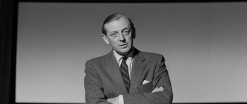 Movie still from “The Three Faces of Eve” (1957), directed by Nunnally Johnson – An older man wearing a suit and tie with his arms crossed; Close Up shot, Low angle