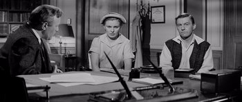 Movie still from “The Three Faces of Eve” (1957), directed by Nunnally Johnson – A woman sitting at a table in front of papers; Medium shot, High angle