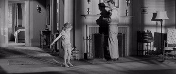 Movie still from “The Three Faces of Eve” (1957), directed by Nunnally Johnson – An old photo of a man and a little girl; Wide shot, Over the shoulder angle