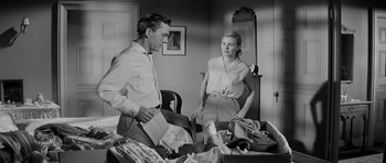 Movie still from “The Three Faces of Eve” (1957), directed by Nunnally Johnson – A man and a woman looking at each other in a cluttered room; Medium shot, Over the shoulder angle