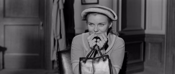 Movie still from “The Three Faces of Eve” (1957), directed by Nunnally Johnson – A woman holding a purse in her hands; Close Up shot, High angle