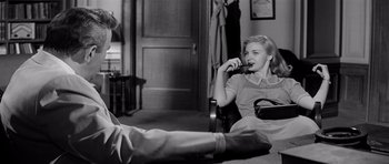 Movie still from “The Three Faces of Eve” (1957), directed by Nunnally Johnson – A woman sitting in a chair with a toothbrush in her mouth; Medium shot, Low angle