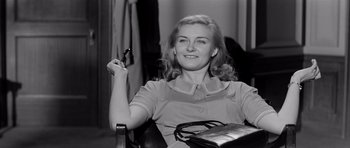 Movie still from “The Three Faces of Eve” (1957), directed by Nunnally Johnson – A black and white photo of a woman holding a cell phone; Medium shot, Low angle