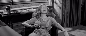 Movie still from “The Three Faces of Eve” (1957), directed by Nunnally Johnson – A woman sitting in a chair with her mouth open; Medium shot, High angle