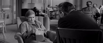 Movie still from “The Three Faces of Eve” (1957), directed by Nunnally Johnson – An older man and a younger woman sitting in a chair; Medium shot, Over the shoulder angle