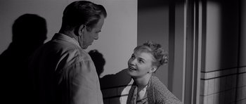 Movie still from “The Three Faces of Eve” (1957), directed by Nunnally Johnson – An older man standing next to an older woman; Medium shot, Over the shoulder angle