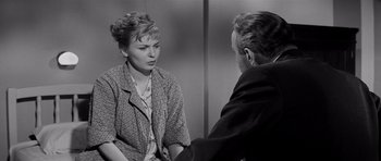 Movie still from “The Three Faces of Eve” (1957), directed by Nunnally Johnson – An old photo of a man and a woman talking to each other; Medium shot, Over the shoulder angle