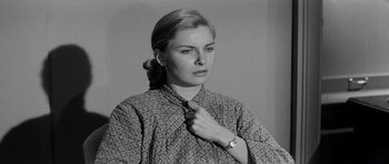 Movie still from “The Three Faces of Eve” (1957), directed by Nunnally Johnson – A woman adjusting her tie in a black and white photo; Close Up shot, Over the shoulder angle